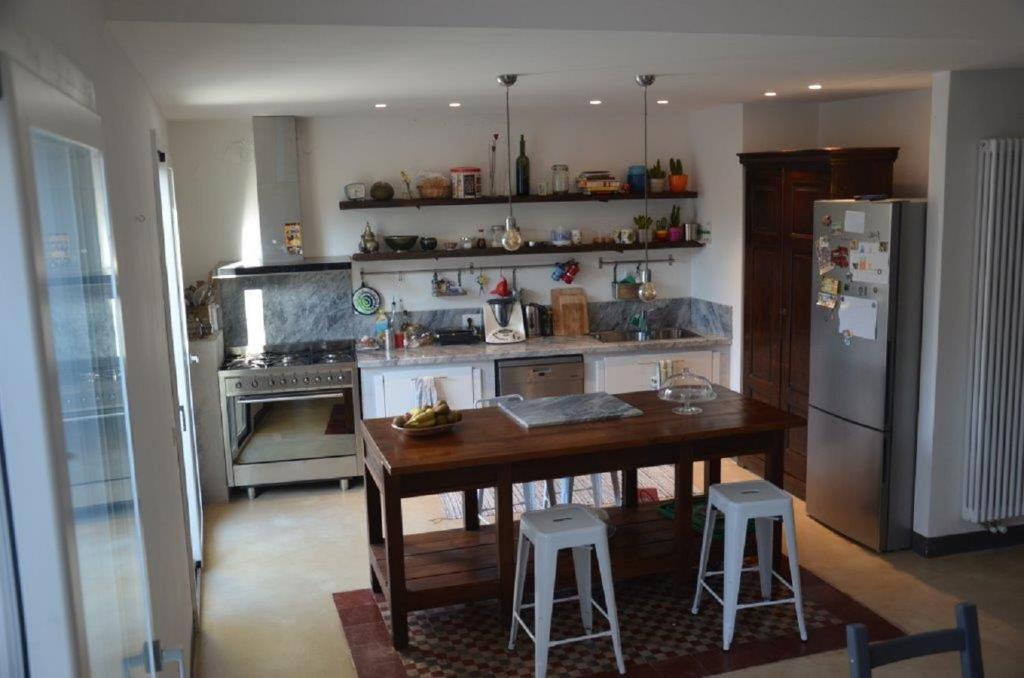 een keuken met een houten tafel en een koelkast bij Il nido di Ale in San Gregorio di Catania