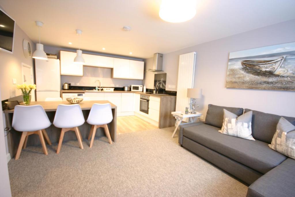 a living room with a couch and a kitchen at Brockhurst Lodge in Gosport