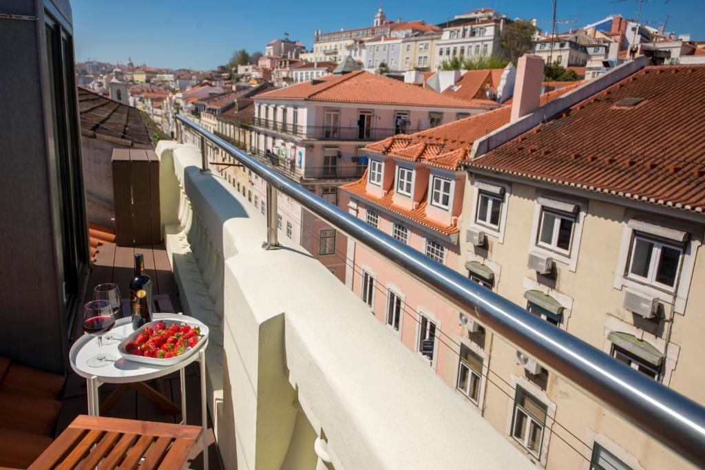 a bowl of strawberries on a table on a balcony at A Captivating Apartment close to River Tagus in Lisbon in Lisbon