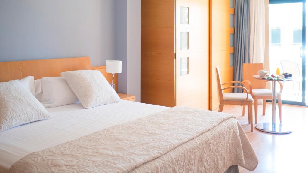 a bedroom with a bed and a table and a chair at Hotel Clipper - EL DELFÍN VERDE RESORTS - Platja de Pals in Torroella de Montgrí