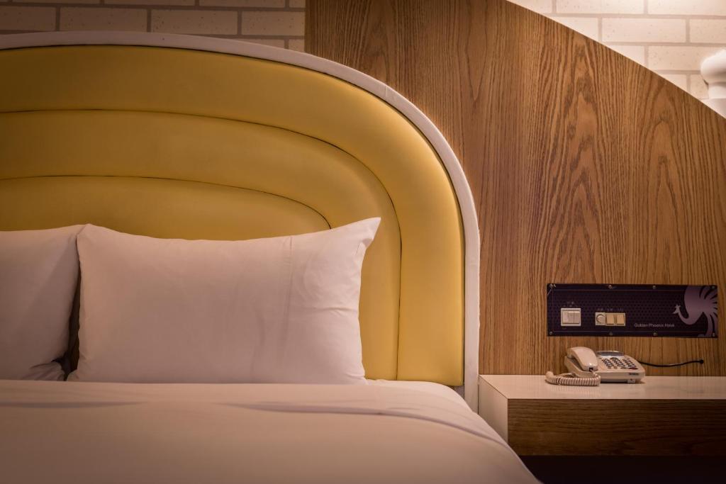 Postel nebo postele na pokoji v ubytování Golden Phoenix Hotel