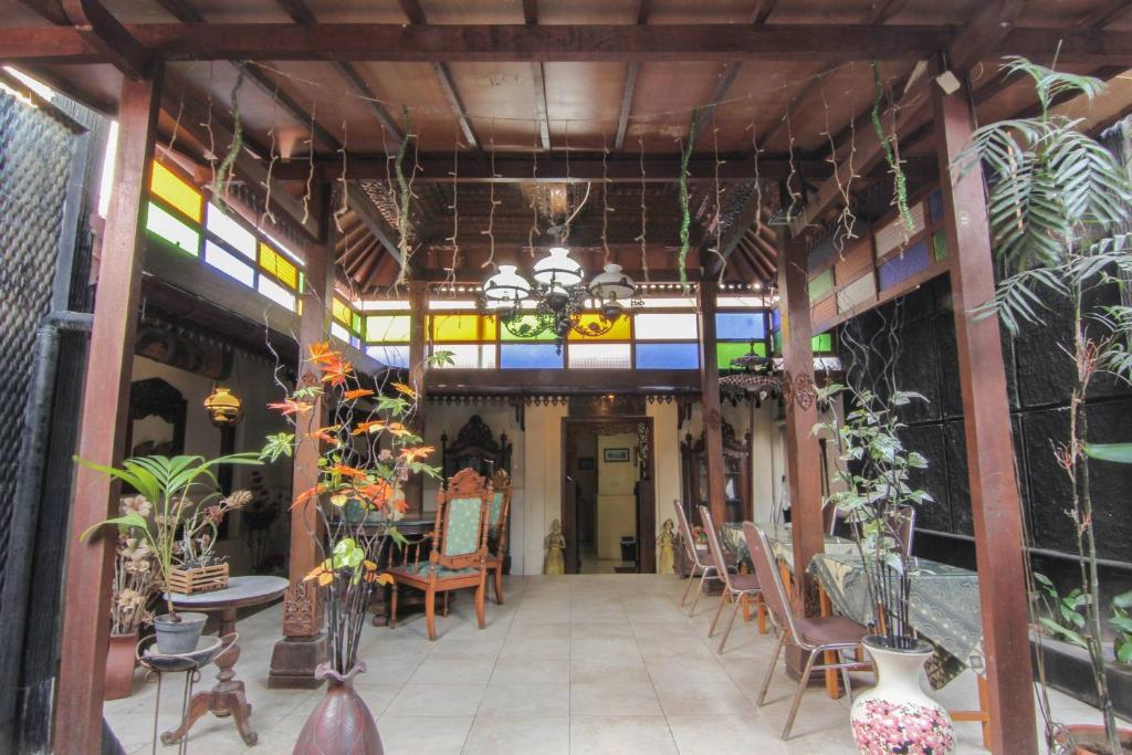 um quarto com uma mesa, cadeiras e janelas em RedDoorz near Galeria Mall 2 em Yogyakarta