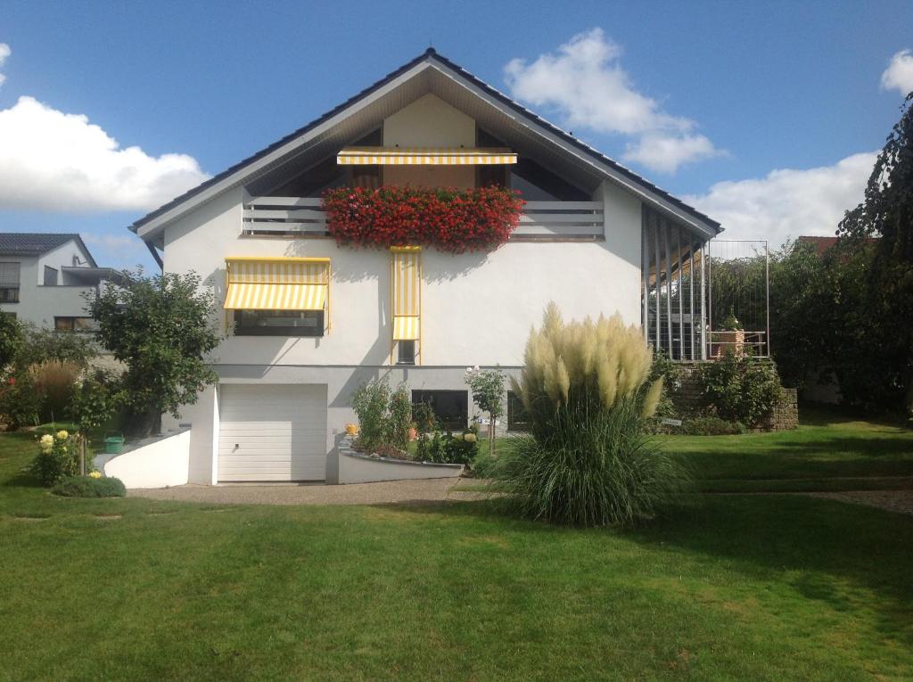 a white house with flowers on the side of it at Haus Framinger in Volkach