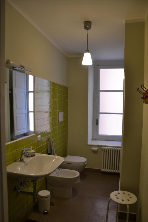 łazienka z umywalką, toaletą i oknem w obiekcie Casa Arcoiris w mieście Neapol