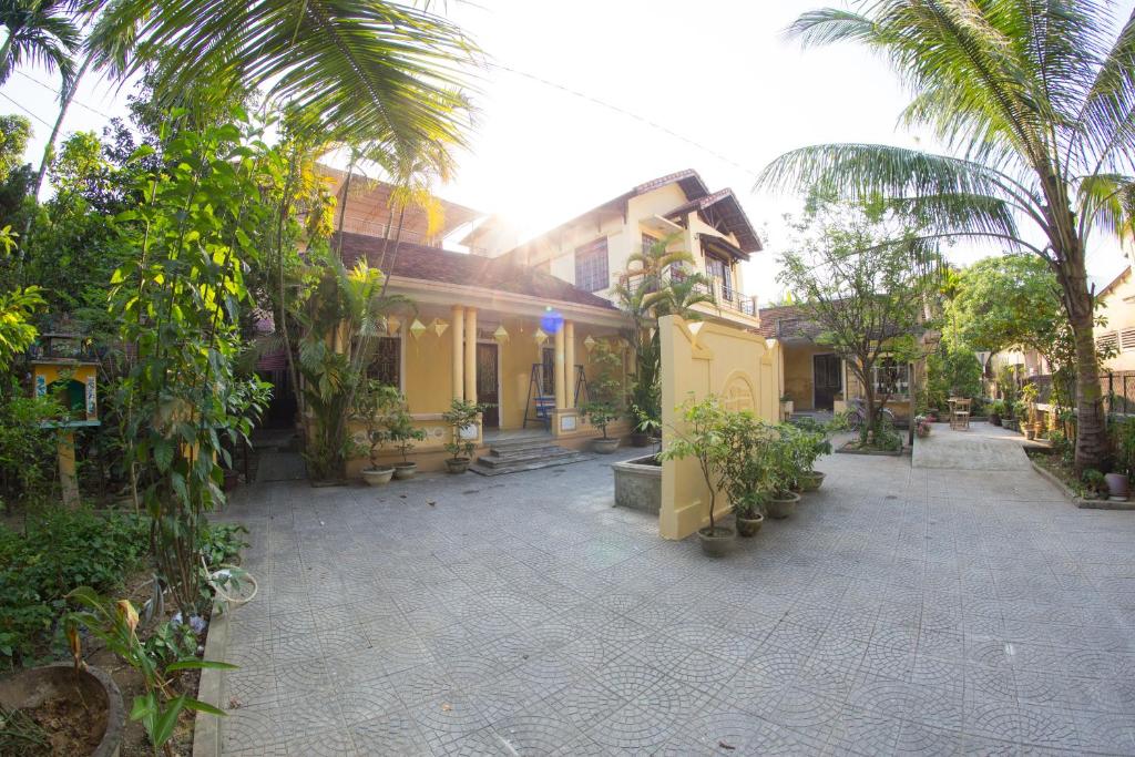 a courtyard of a house with trees and plants at Le Robinet Homestay in Hue