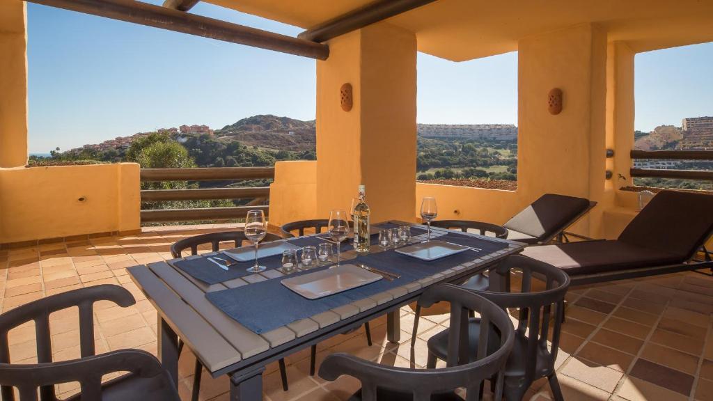 a dining room with a table and chairs on a balcony at Coto Real Andros 201 in Manilva