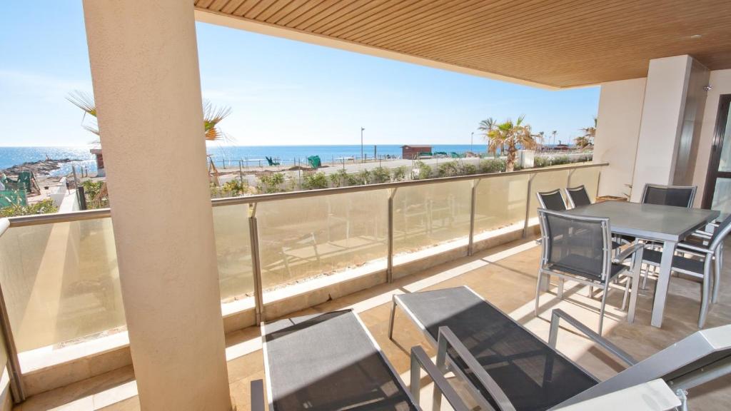 balcón con mesa, sillas y vistas al océano en Marina del Castillo 305 en Manilva