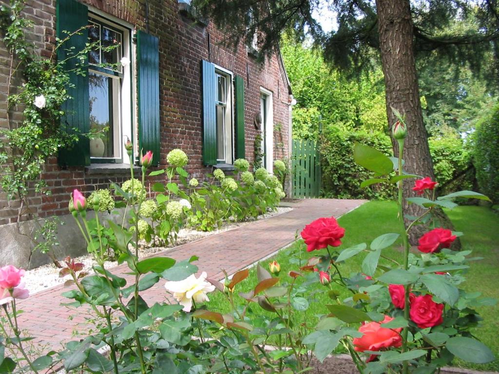 ein Backsteinhaus mit Rosengarten in der Unterkunft De Erfdijk in Herpen