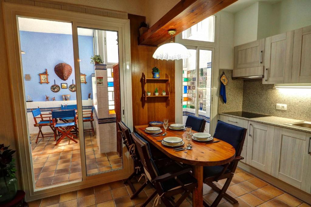 シッチェスにあるDortoka by Hello Homes Sitgesのキッチン、ダイニングルーム(木製のテーブルと椅子付)