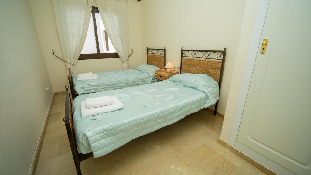 2 Einzelbetten in einem kleinen Zimmer mit Fenster in der Unterkunft Marina Real 245 in Manilva