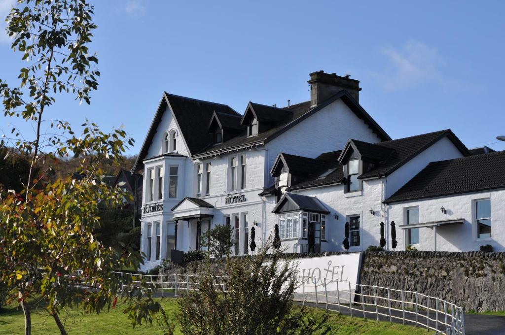 a large white house with a black roof at Kames Hotel in Tighnabruaich