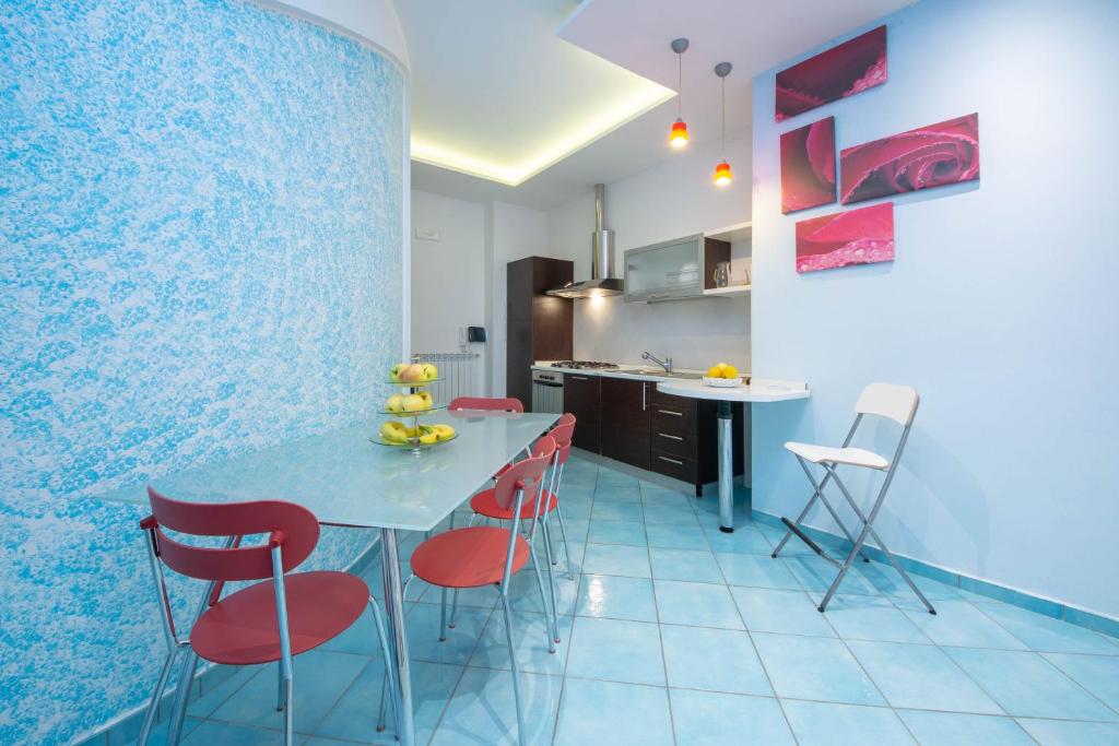 uma cozinha com uma mesa azul e cadeiras vermelhas em casa la perla em Minori