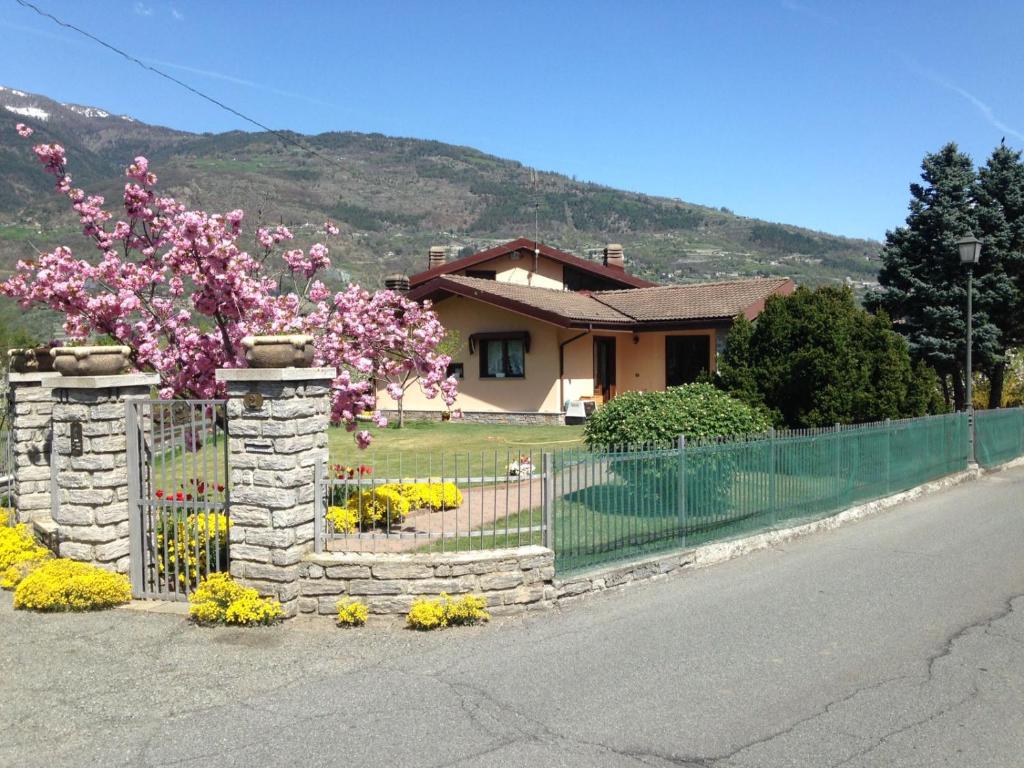 einen Zaun vor einem Haus mit Blumen in der Unterkunft Casa di Tia CIR 0067 in Aosta