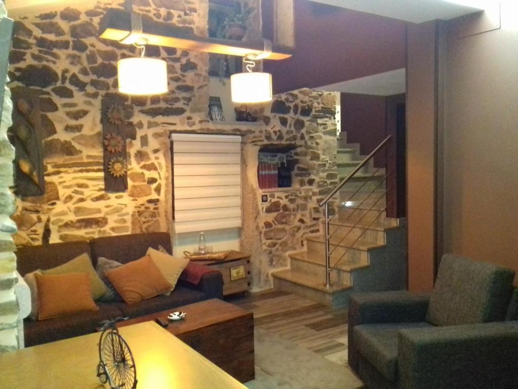 uma sala de estar com uma parede de pedra e um sofá em Casa Mara-Pidre em Corunha