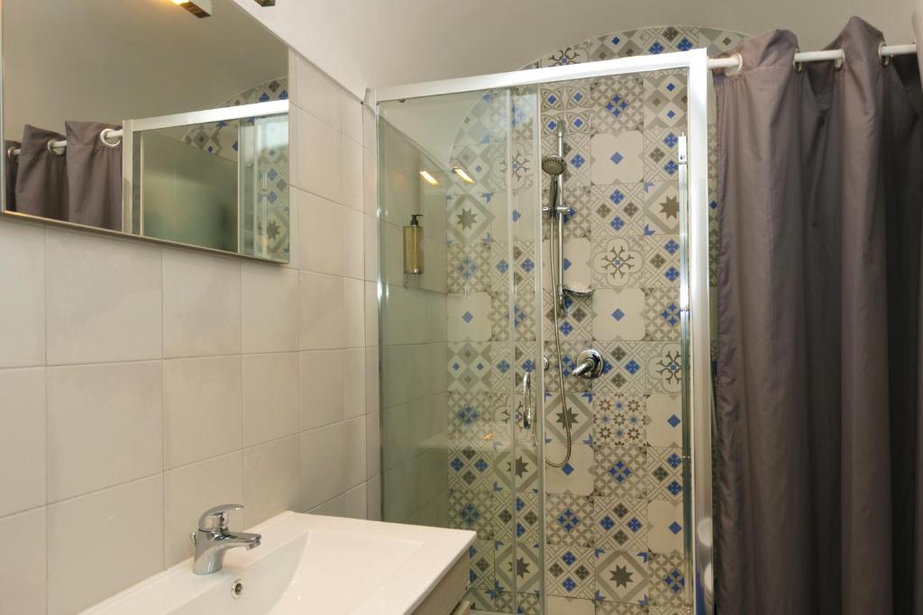 a bathroom with a shower with a sink and a mirror at To Be Capri in Capri