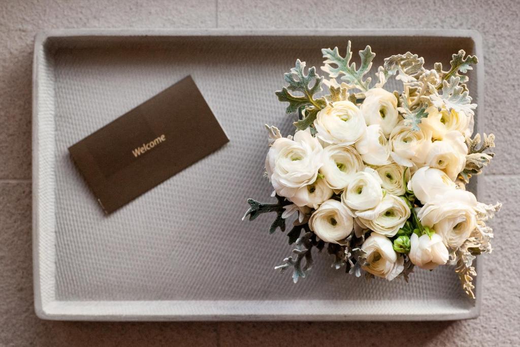 a bouquet of white flowers on a plate with a card at Daios Luxury Living in Thessaloniki