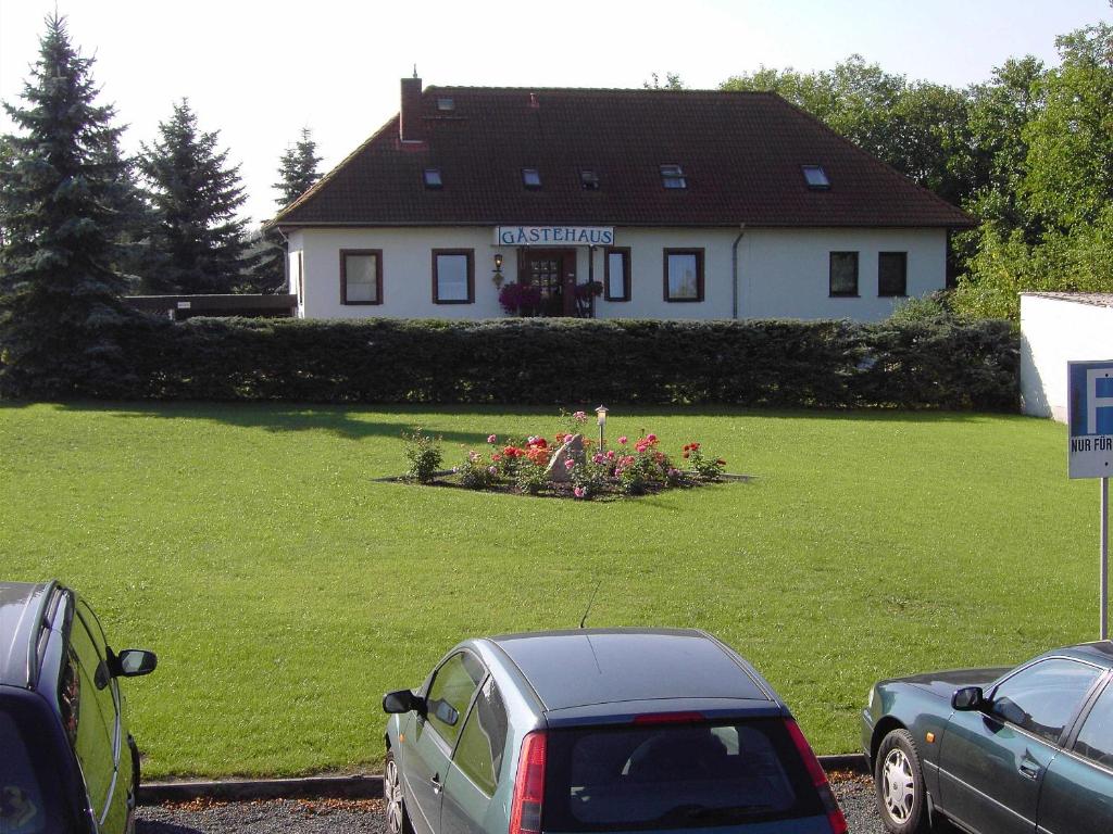 a house with cars parked in front of a yard at Gästehaus Pension Heß - Das kleine Hotel in Güstrow