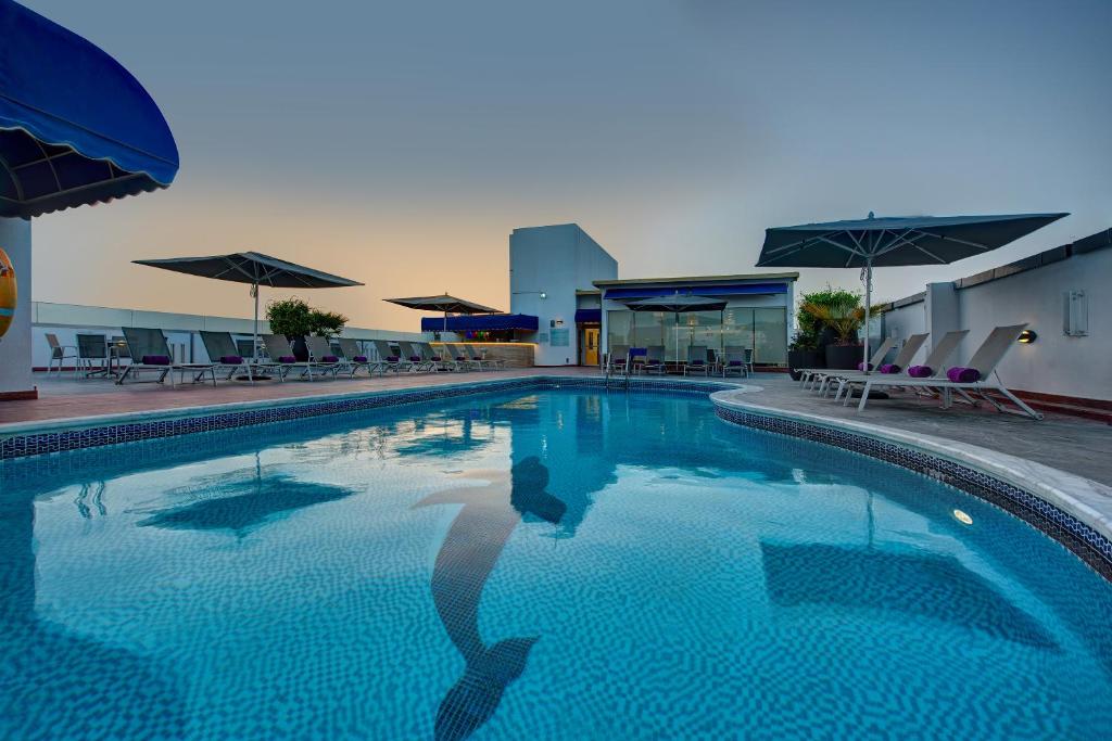 a person is standing in a swimming pool at J5 RIMAL Hotel Apartments in Dubai