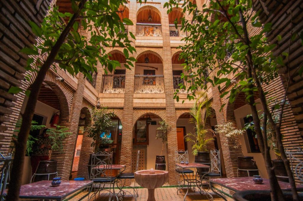 a building with tables and chairs in a courtyard at Riad Assia in Marrakesh