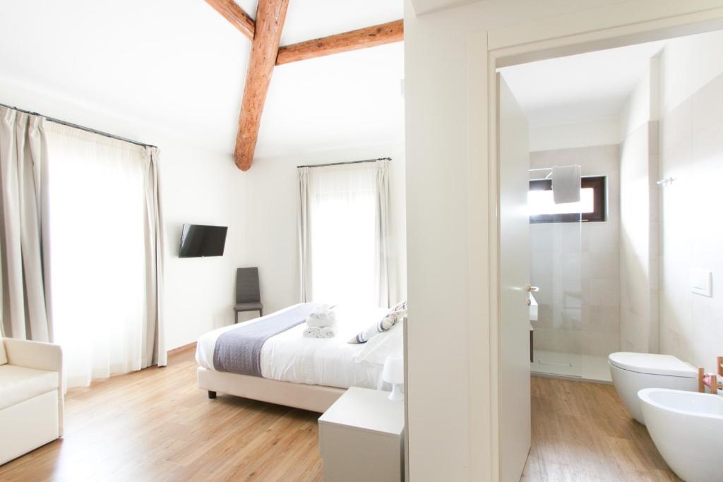 Habitación blanca con cama y lavabo en Garda Relais, en Castelnuovo del Garda