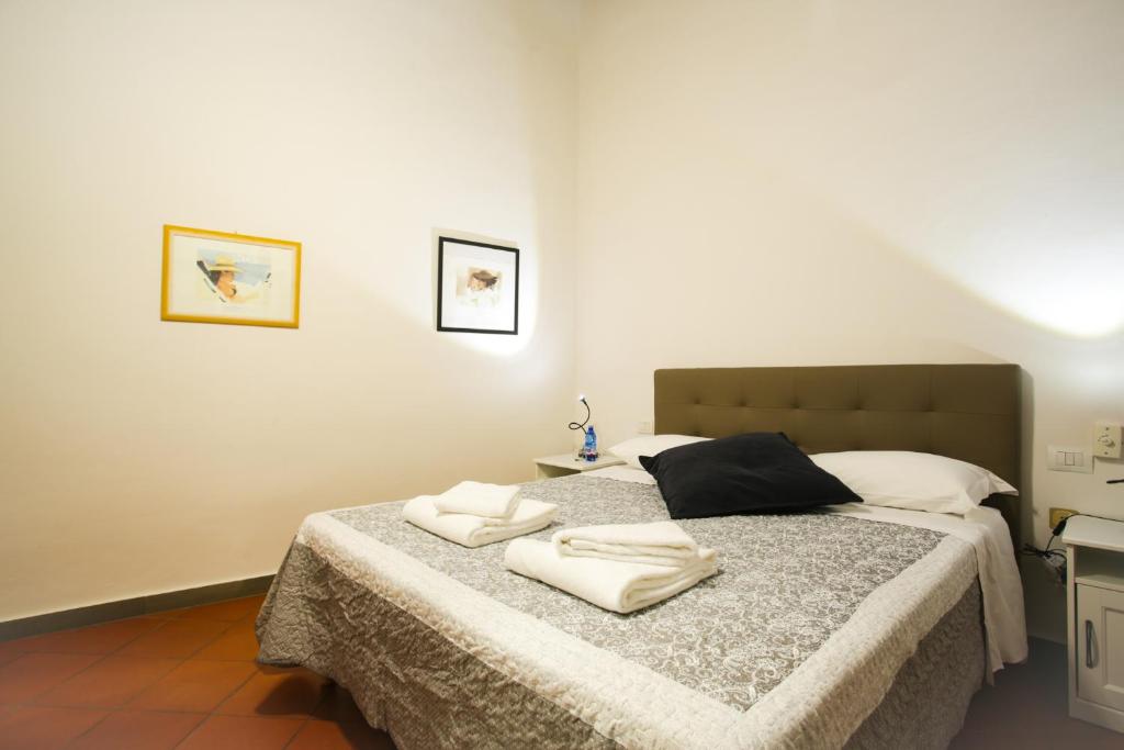 フィレンツェにあるVia Guelfa Apartmentのベッドルーム1室(ベッド1台、タオル2枚付)