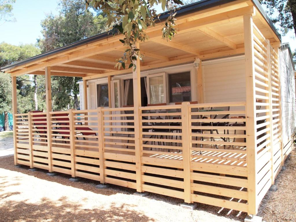 une maison en bois entourée d'une clôture dans l'établissement Mobile Home Heaven Camping park Soline, à Biograd na Moru
