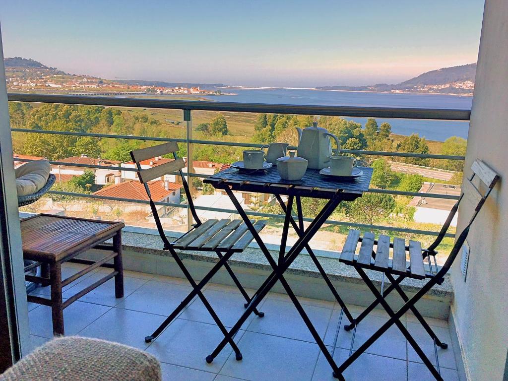 uma mesa e cadeiras numa varanda com vista em Terraços de Seixas em Caminha