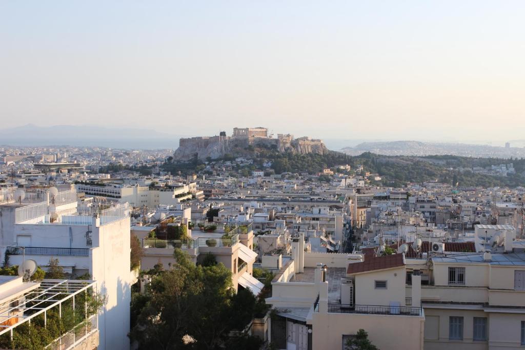 vistas a una ciudad con una montaña en el fondo en Acropolis view penthouse, en Atenas