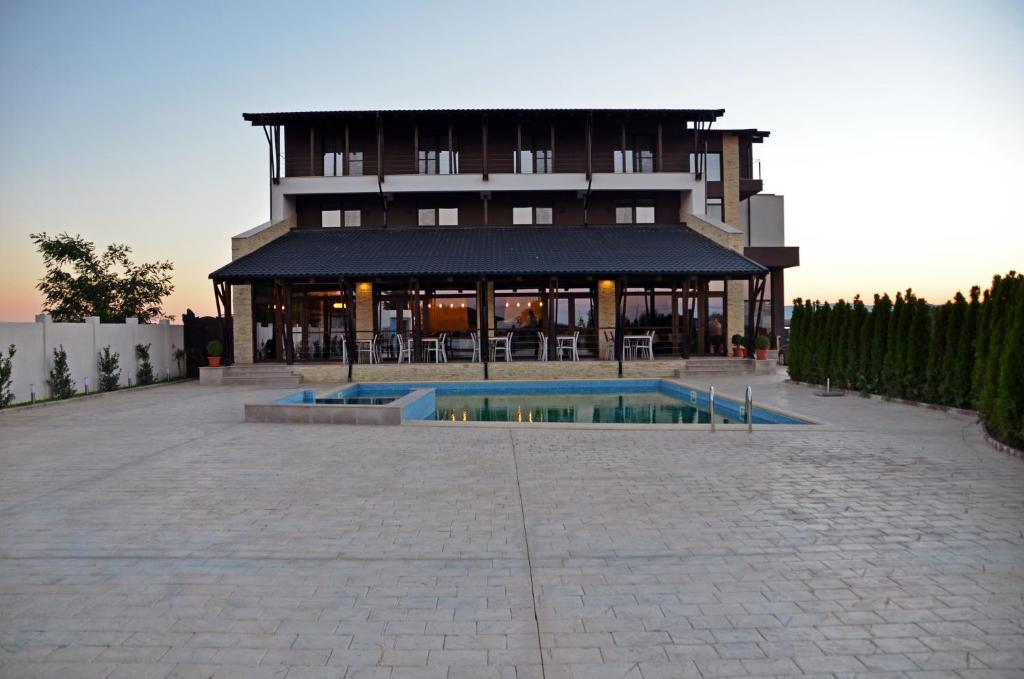 a building with a pool in front of it at Pensiunea Sara in Focşani