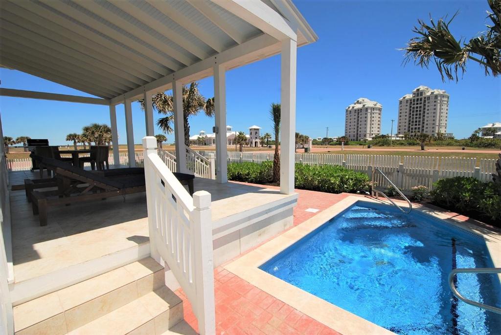 a small swimming pool on a patio with a gazebo at Coastal Home in South Padre Island