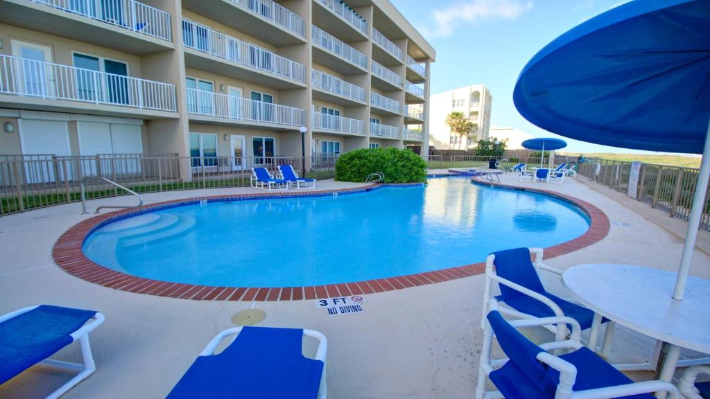 a pool with chairs and tables and a hotel at Edgewater Condo Unit #304 in South Padre Island