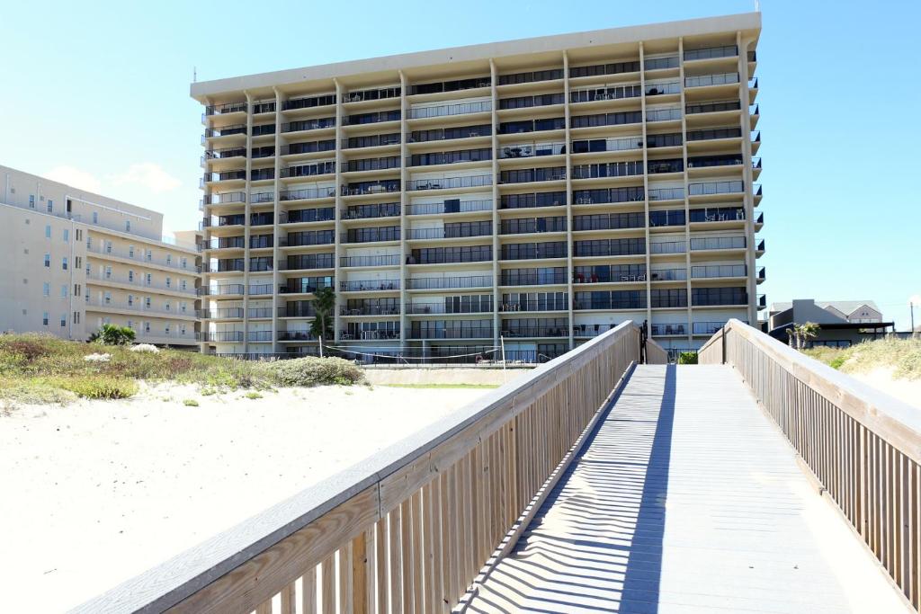 a boardwalk leading to a large building on the beach at Ocean Vista Condo Unit #1201 in South Padre Island