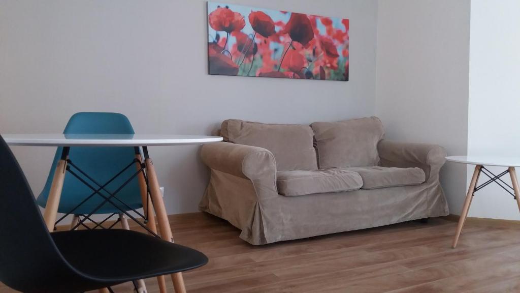 a living room with a couch and a table and chairs at Apartamenty I.M.A. in Poznań