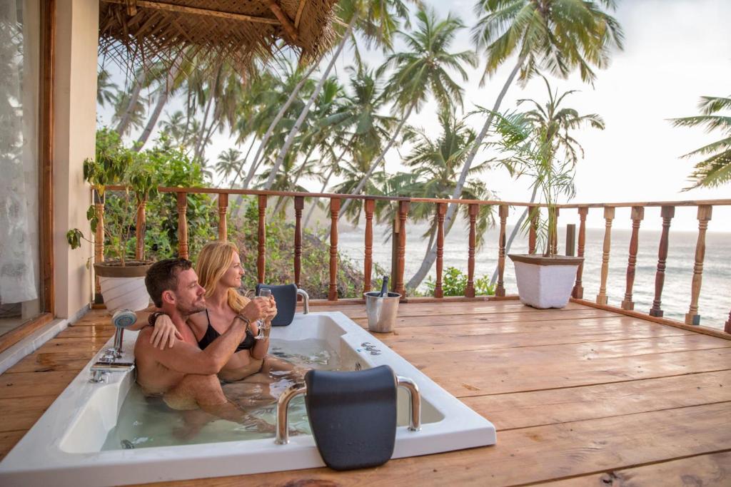 een man en vrouw in een bad op een terras bij The Cape Goa in Cabo de Rama