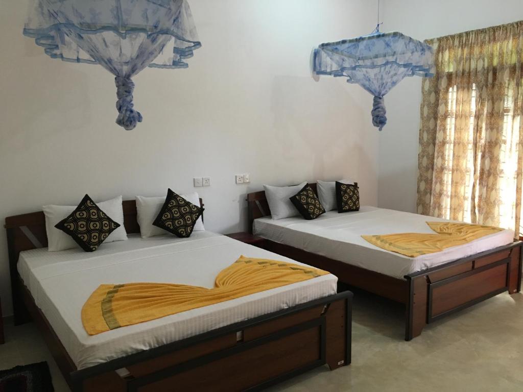 two beds sitting next to each other in a room at Sigiri Rangana Guesthouse in Sigiriya