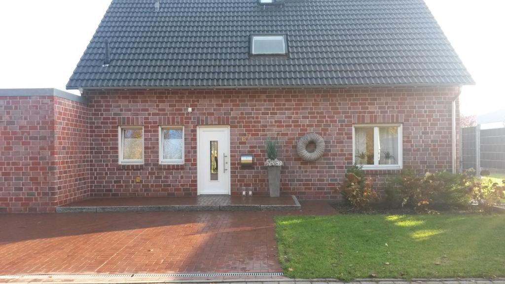 a red brick house with a white door at Hostel Nordkirchen by Frerichmann in Nordkirchen