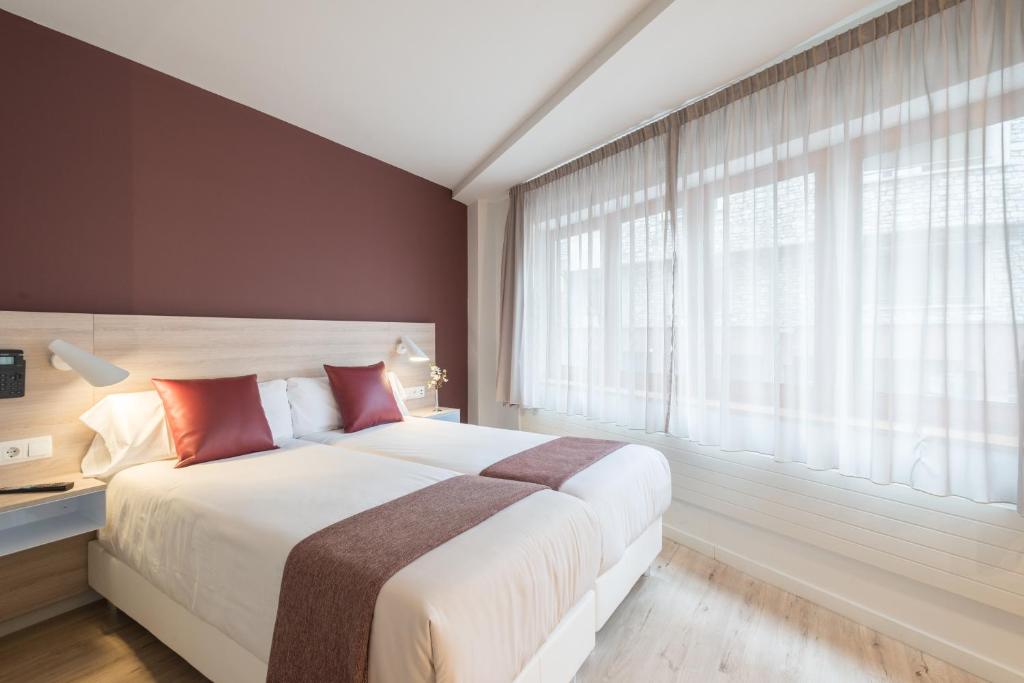Hotel & Aparthotel Cosmos في أندورا لا فيلا: غرفة نوم بسرير كبير ونافذة كبيرة