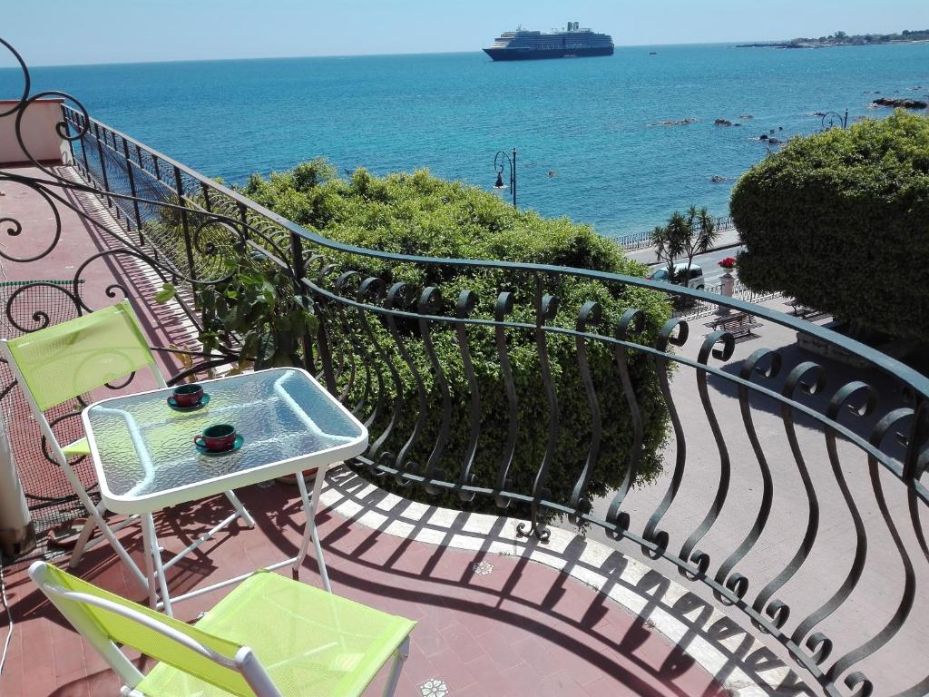 balkon ze stołem i krzesłami oraz oceanem w obiekcie Plaza w mieście Giardini Naxos