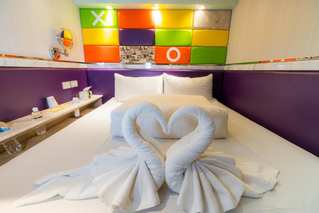 a bedroom with a bed with two swans forming a heart at Kenting Space Capsule in Kenting