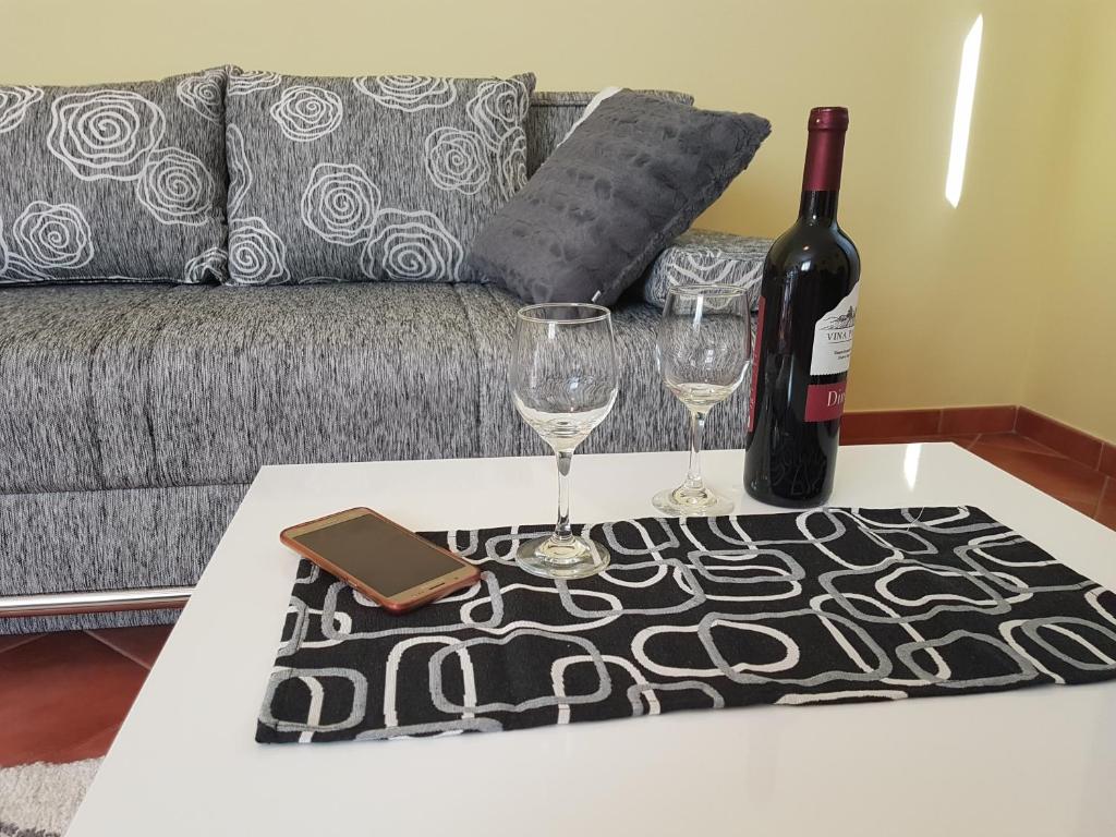 a bottle of wine and two glasses on a table at Apartments Ella in Rovinj