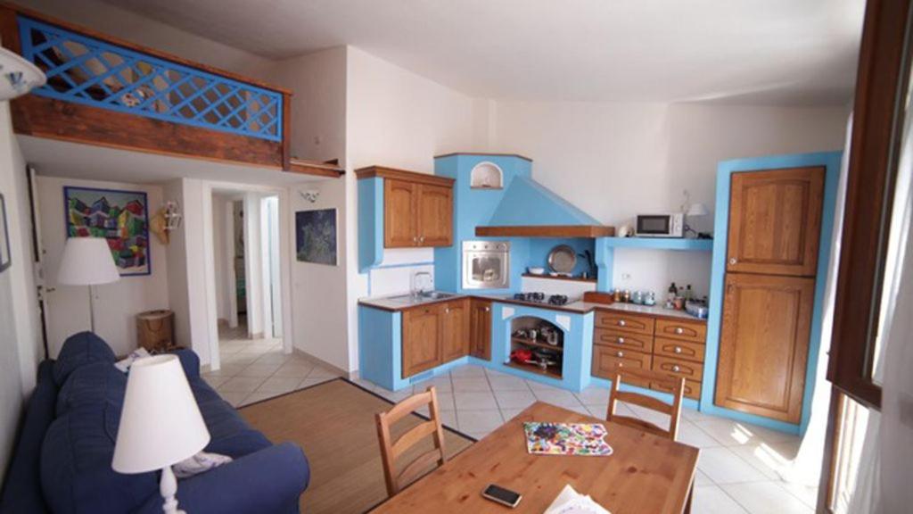 een woonkamer met een blauwe bank en een tafel bij Vicino al mare nel cuore di Santa Teresa Gallura in Santa Teresa Gallura