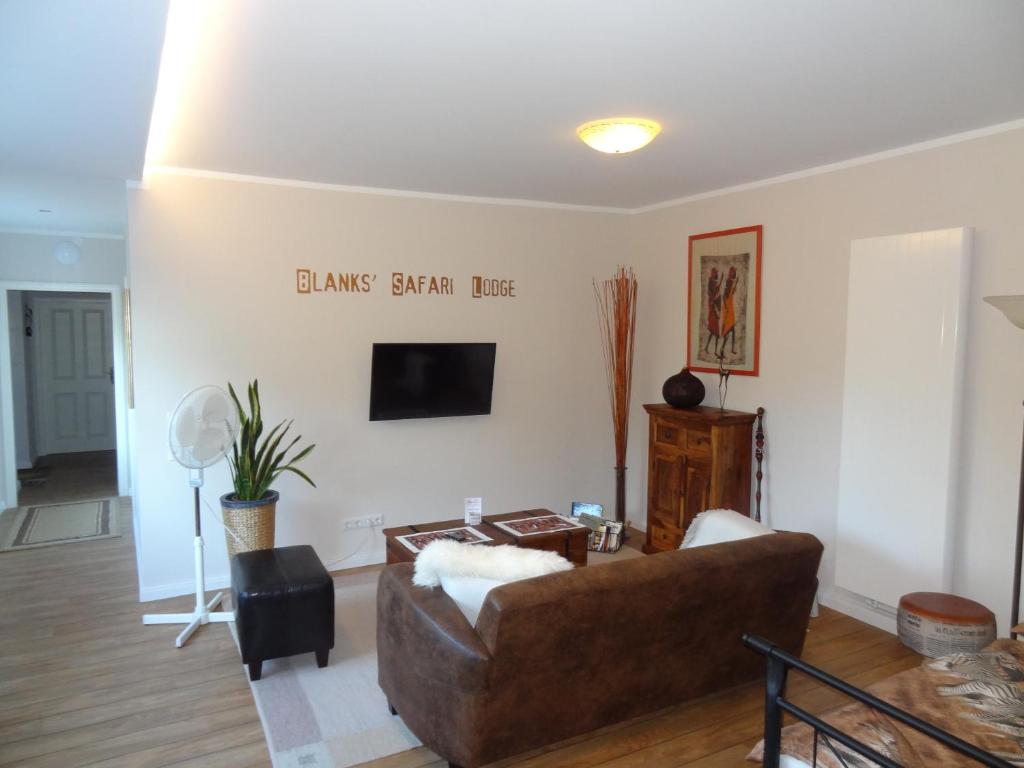 a living room with a couch and a tv at Blanks Safari Lodge in Klein Schwaß