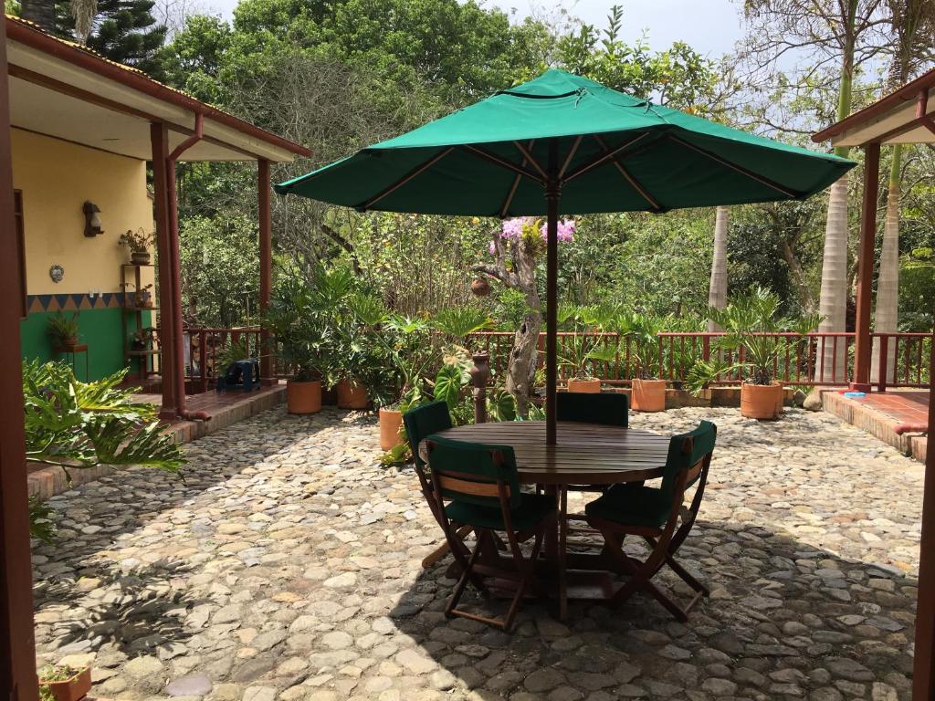 - une table et des chaises avec un parasol sur la terrasse dans l'établissement Quinta Sans-Soucis, à Choachí