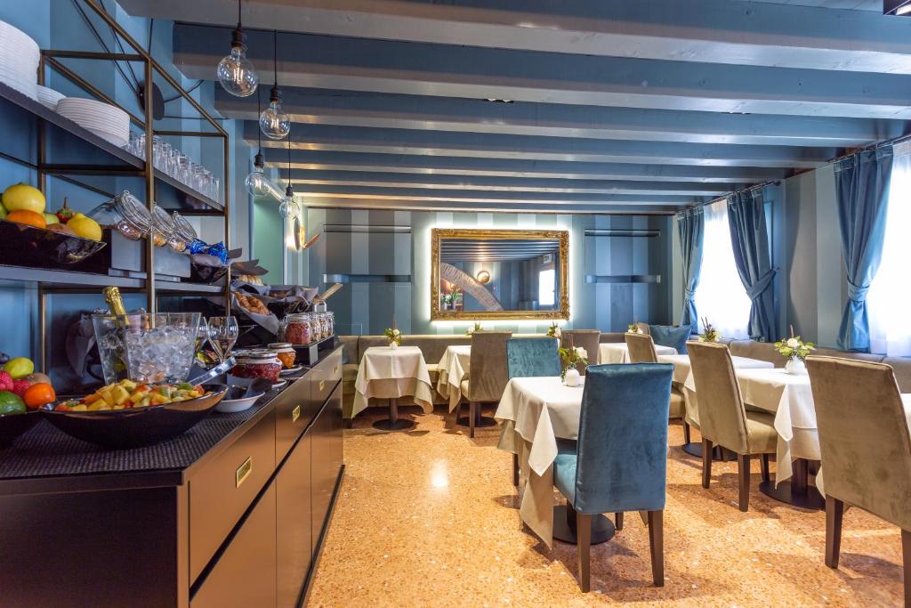 a restaurant with blue walls and tables and chairs at Hotel Tiziano in Venice