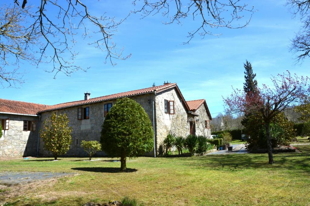 ein altes Steinhaus mit einem Baum im Hof in der Unterkunft Iberik Casa Vilamor in Vilamor