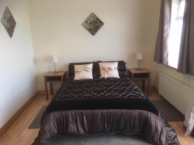 um quarto com uma cama grande e duas mesas em Baurleigh studio apartment P72F340 em Lissaphooca Cross Roads