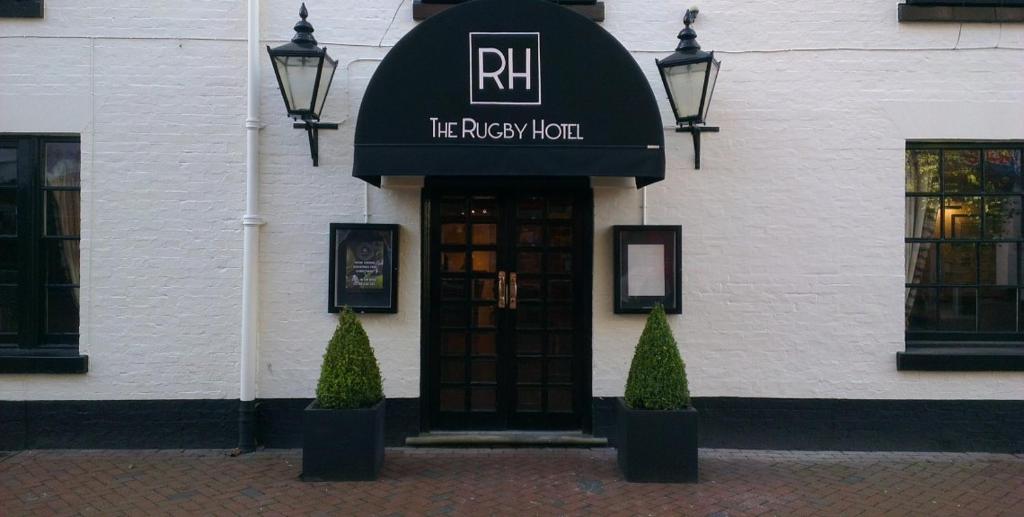 a building with a sign on the front of a building at The Rugby Hotel in Rugby