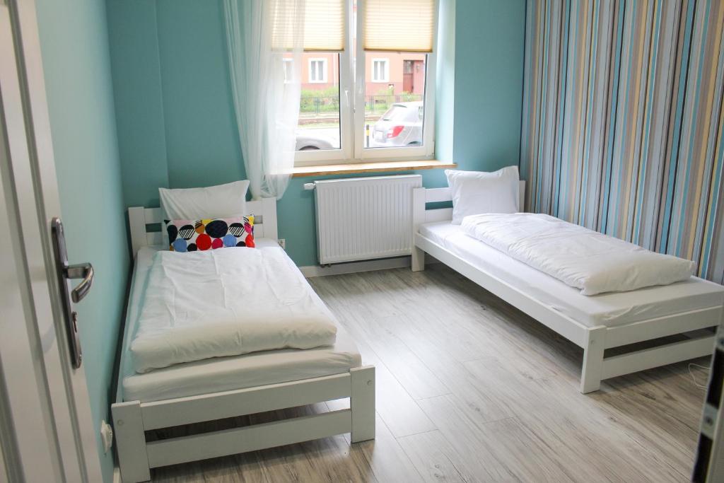 グダニスクにあるPokoje Kartuskaのベッド2台と窓が備わる小さな客室です。
