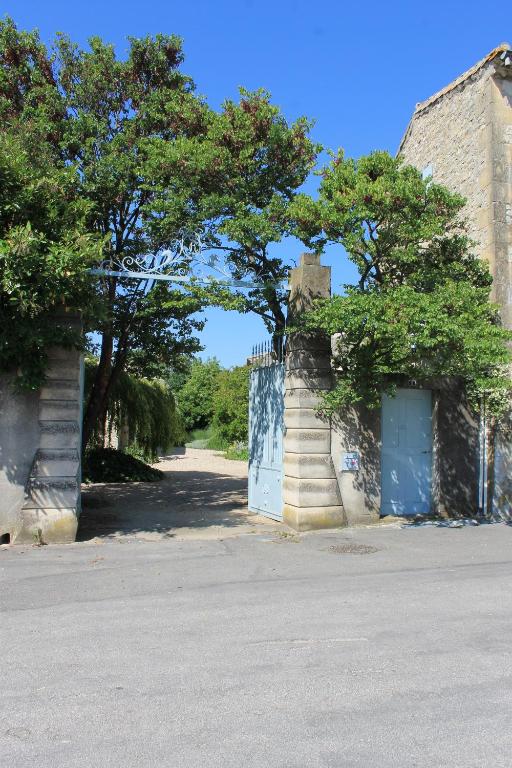 eine Straße mit Bäumen und ein Gebäude mit einem Tor in der Unterkunft La Rôse in Saint-Gervasy
