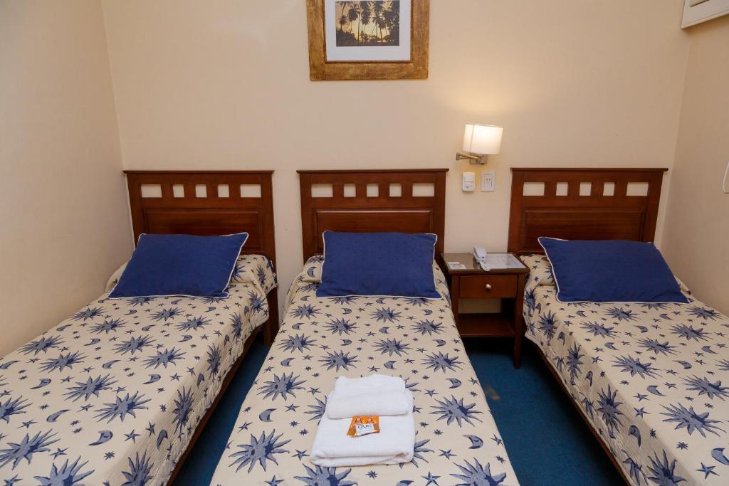 two beds in a room with blue and white sheets at Hotel Federico I in Concordia